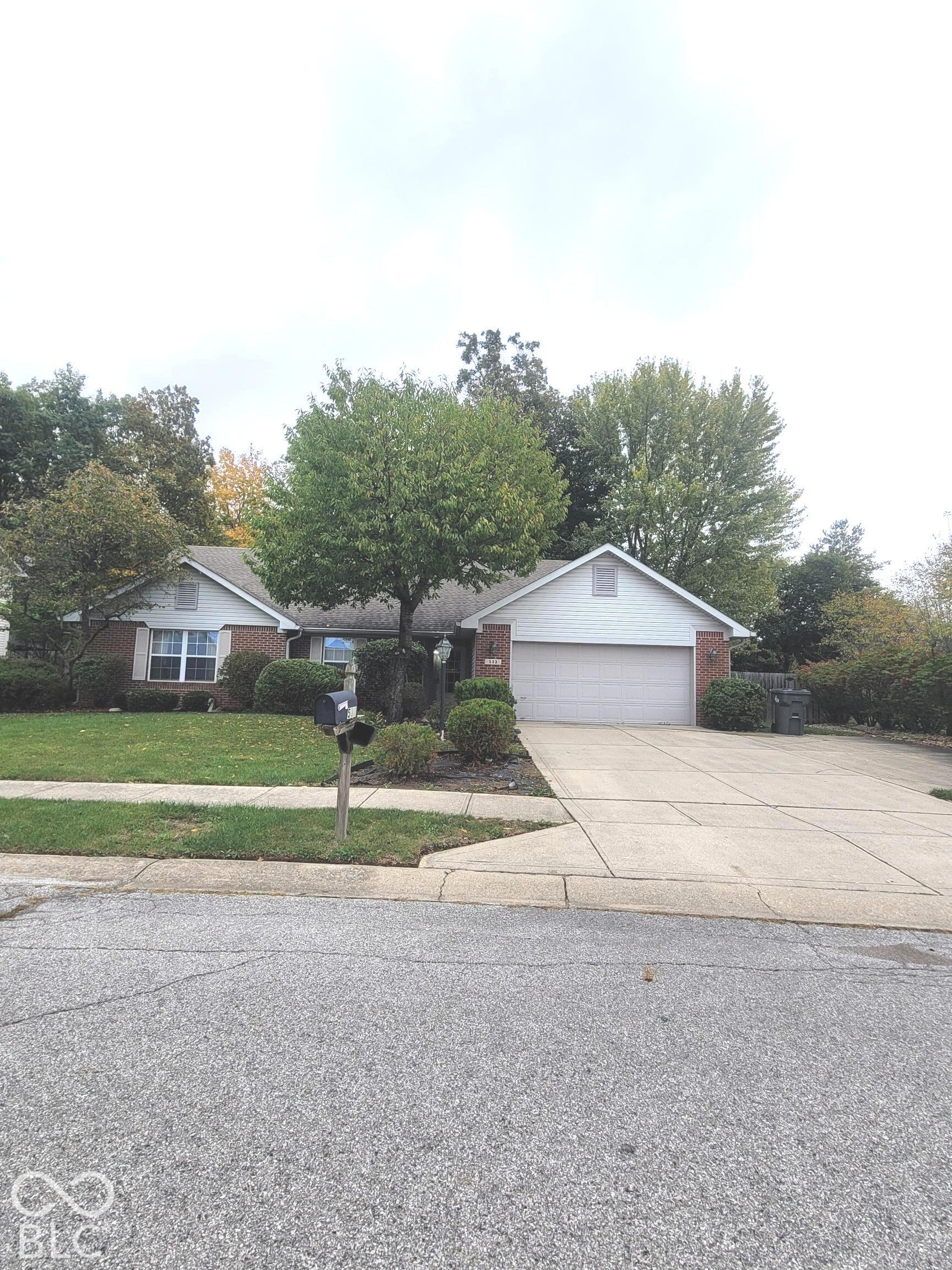 Single-story exterior featuring a brick and siding facade, attached two-car garage, concrete driveway extended to accommodate additional parking, and lush landscaping Single-story exterior featuring a brick and siding facade, attached two-car garage, concrete driveway extended to accommodate additional parking, and lush landscaping