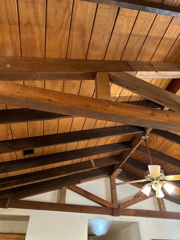 Room details with ceiling fan, beamed ceiling, and wooden ceiling