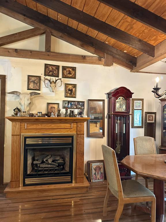 Dining room featuring hardwood / wood-style flooring, wood ceiling, and lofted ceiling with beams