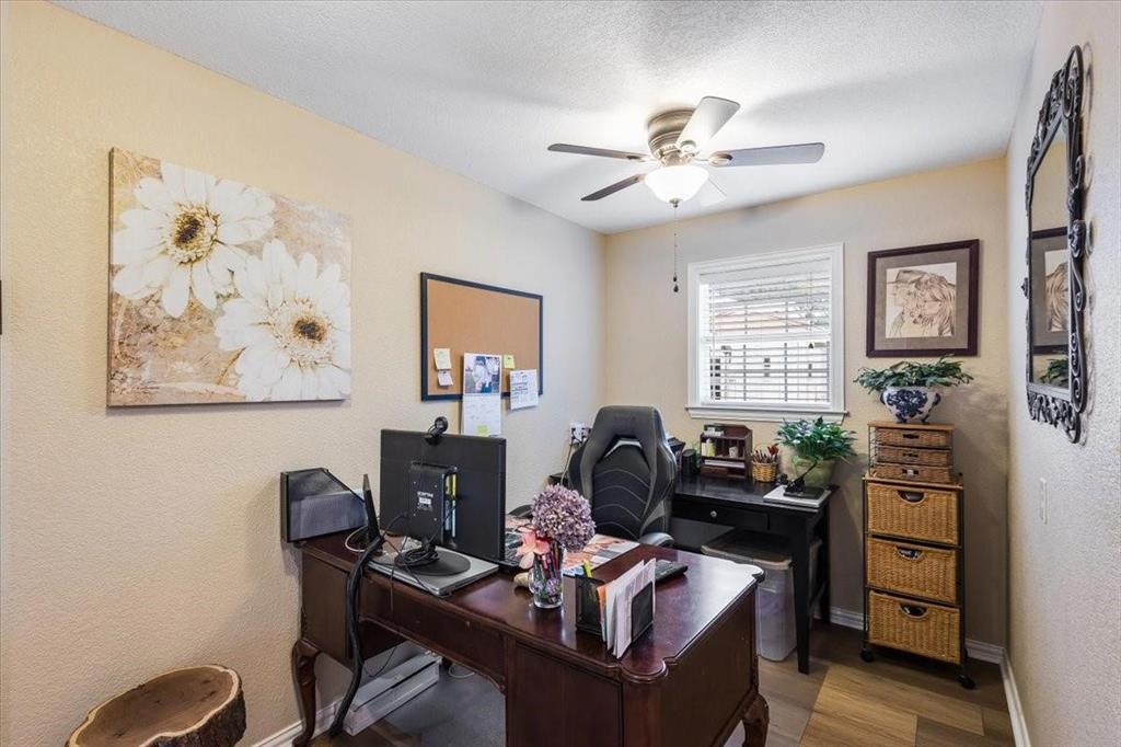 Home office with ceiling fan, a textured ceiling, baseboards, and wood finished floors