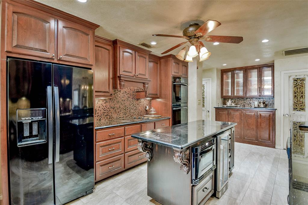 Kitchen with black appliances, ceiling fan, decorative backsplash, dark stone countertops, and recessed lighting