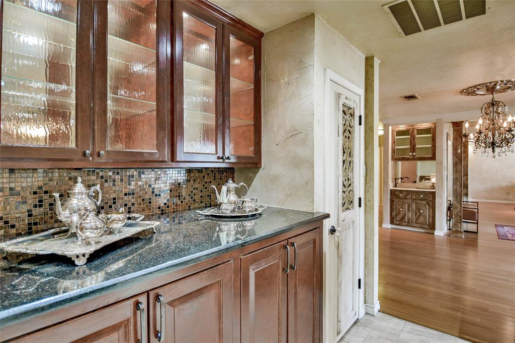 Bar featuring decorative backsplash, a chandelier, and decorative light fixtures