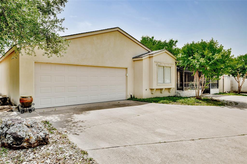 View of front of home with stucco siding, driveway, and an attached garage