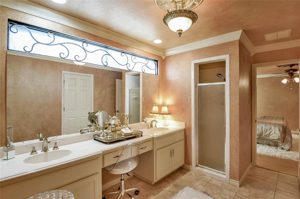 Bathroom featuring double vanity, ornamental molding, a shower stall, tile patterned flooring, and ceiling fan