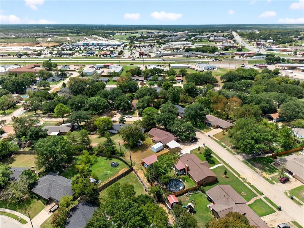 Aerial view of property and surrounding area with nearby suburban area
