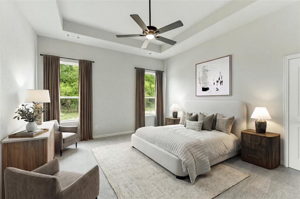 Tray ceiling with a ceiling fan, two windows with drapery, and a white paneled door