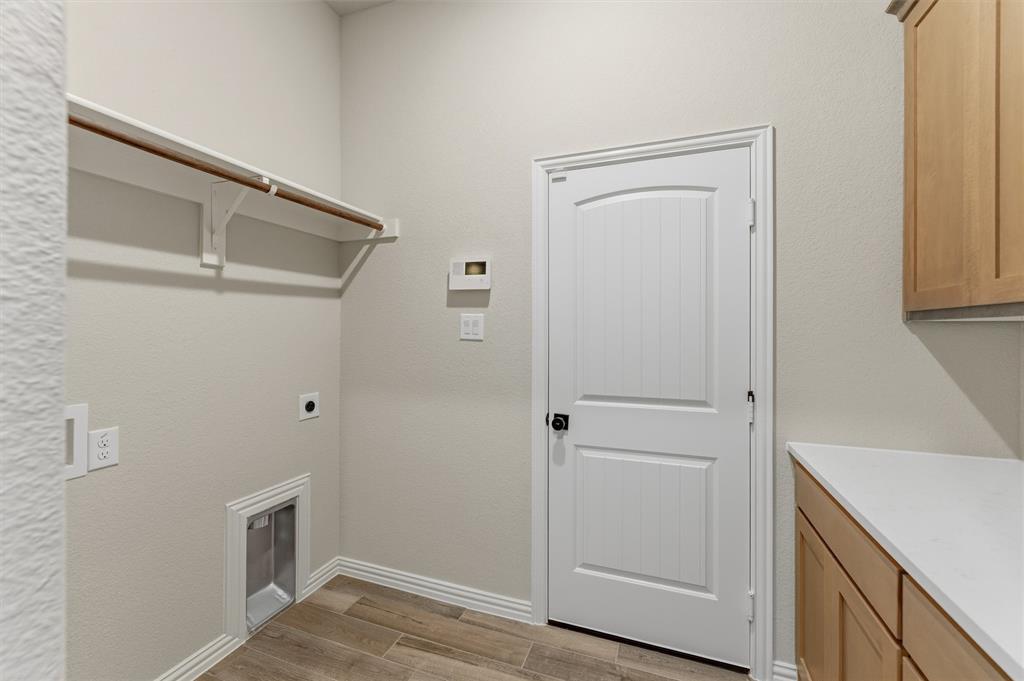 Laundry room featuring light wood-style flooring and hookup for an electric dryer