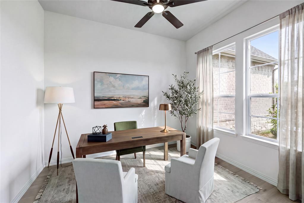 Hardwood-style flooring, white walls, two large windows, and a ceiling fan with integrated lighting