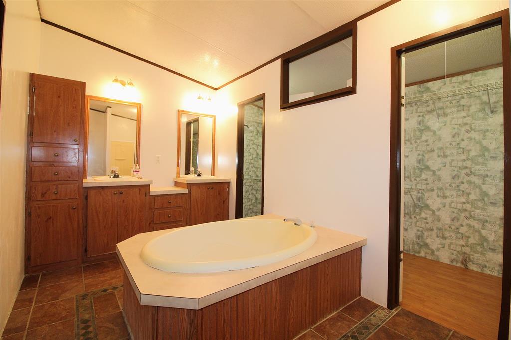 Full bathroom with a garden tub, crown molding, vanity, dark tile patterned floors, and a shower