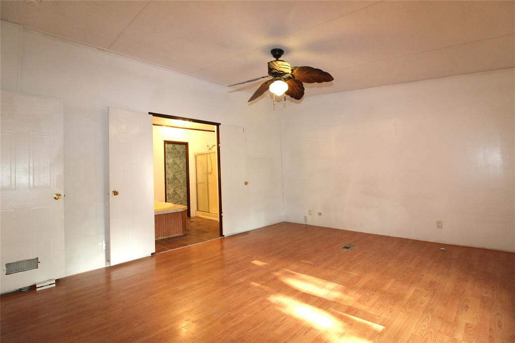 Unfurnished room with wood finished floors and a ceiling fan