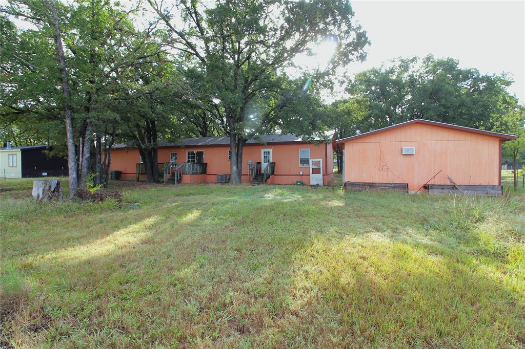 Back of property featuring a deck and a lawn Back of property featuring a deck and a lawn