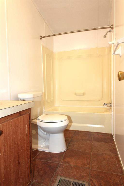 Bathroom #1Full bath featuring vanity, bathtub / shower combination, and dark tile patterned floors