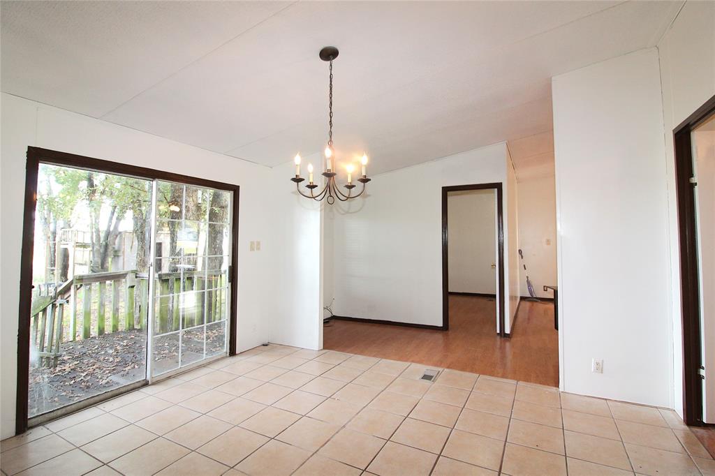 Empty room featuring a chandelier, light tile patterned floors, and lofted ceiling Empty room featuring a chandelier, light tile patterned floors, and lofted ceiling
