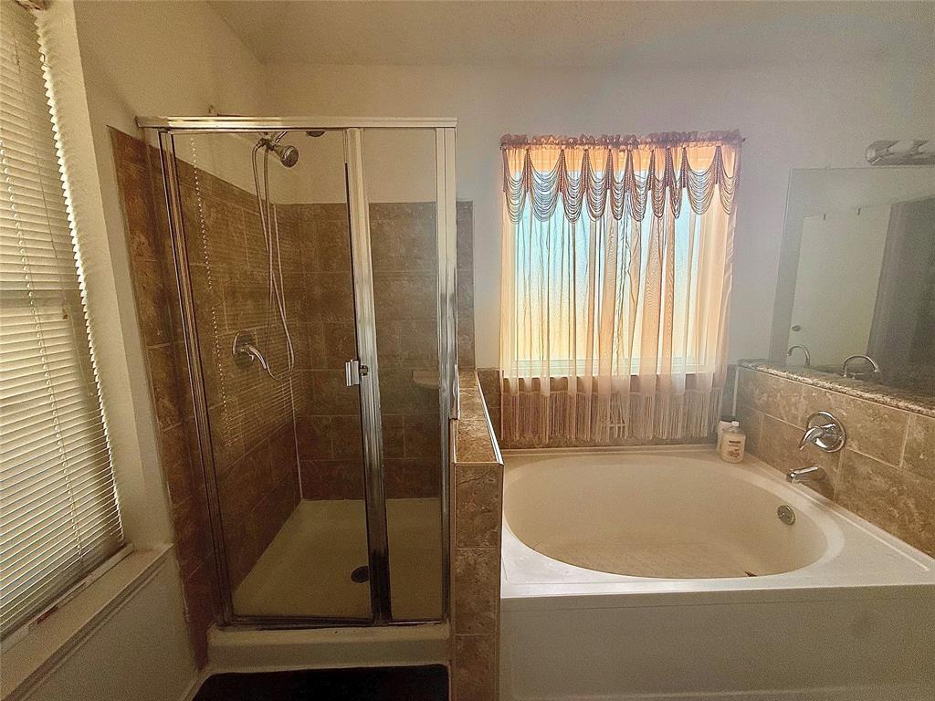 Full bathroom featuring a shower stall and a bath