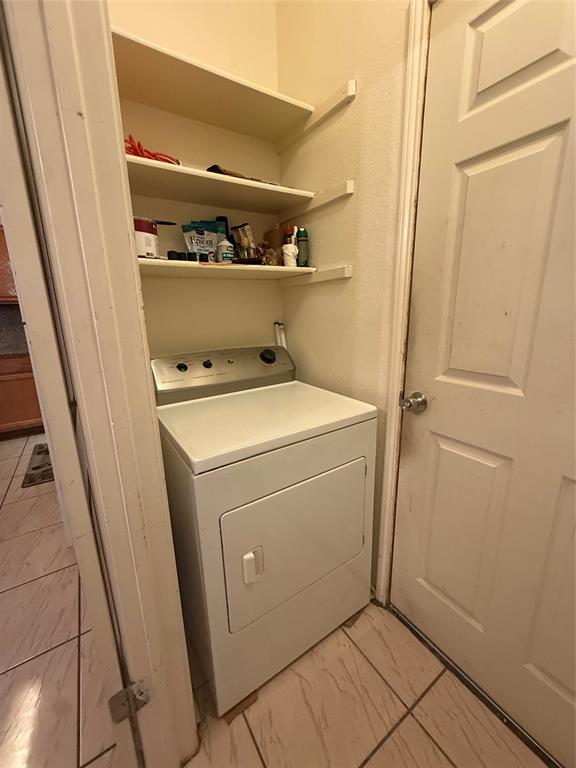 Washroom with washer / dryer and light marble finish floors