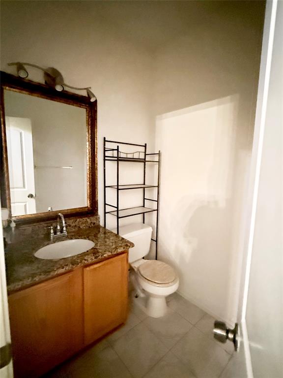 Half bath with vanity and light tile patterned floors