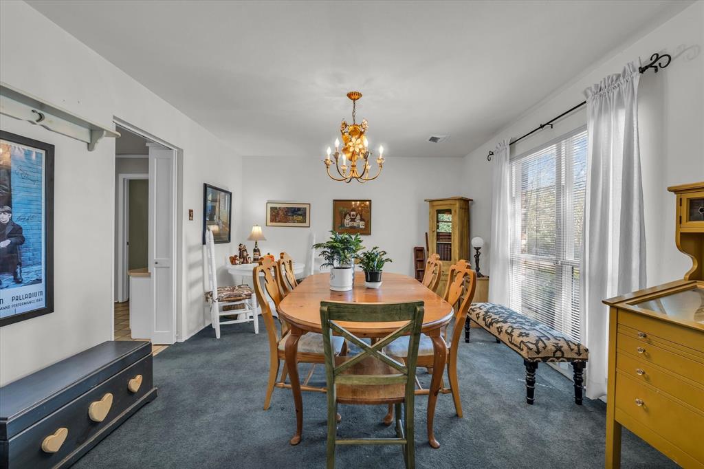 Dining space with dark carpet and a chandelier Dining space with dark carpet and a chandelier