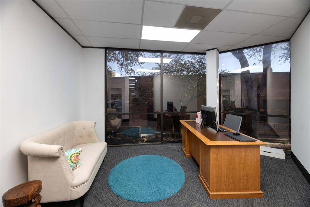 Office area featuring a wall of windows and a drop ceiling