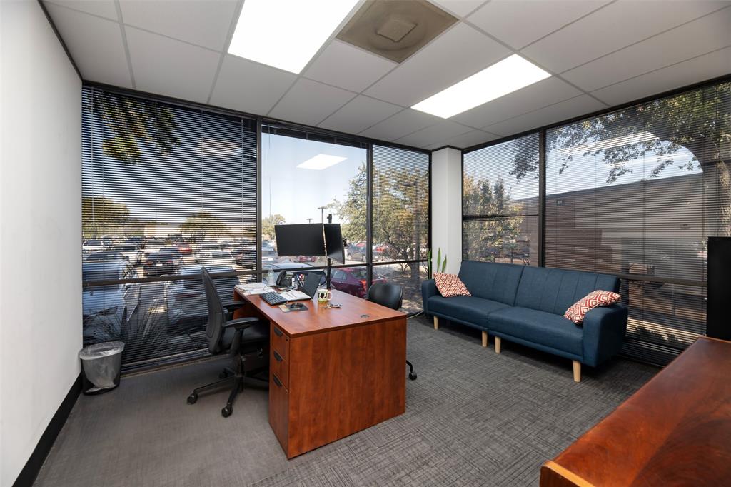 Home office with a wall of windows, healthy amount of natural light, and a paneled ceiling