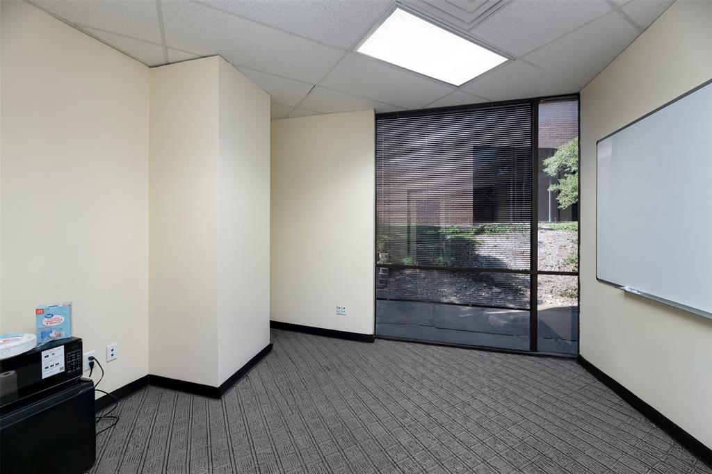Carpeted spare room featuring baseboards and a paneled ceiling