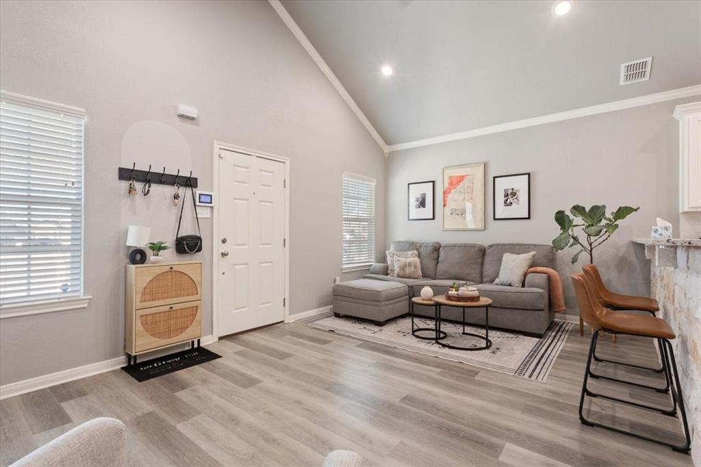 Living room with high vaulted ceiling and light wood-type flooring
