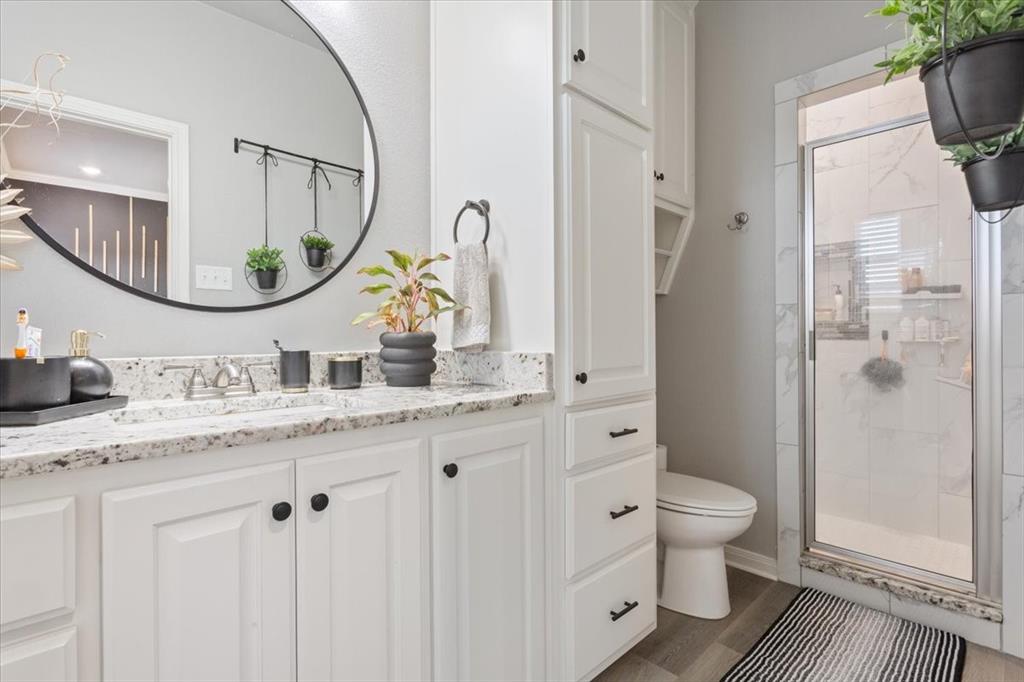 Bathroom with vanity, a shower stall, and dark wood finished floors