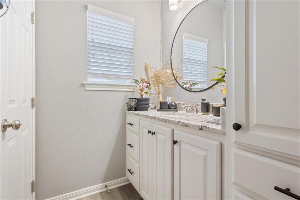 Bathroom featuring vanity, light wood-style floors, and a textured wall