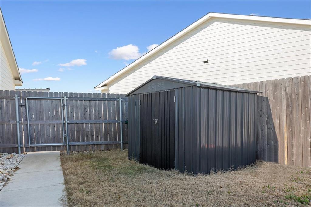 Fenced backyard with a shed and a gate