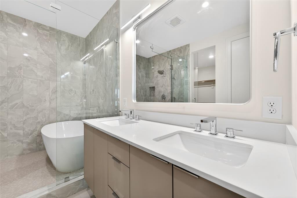 Primary bathroom features double sinks and spacious wet room with freestanding tub.