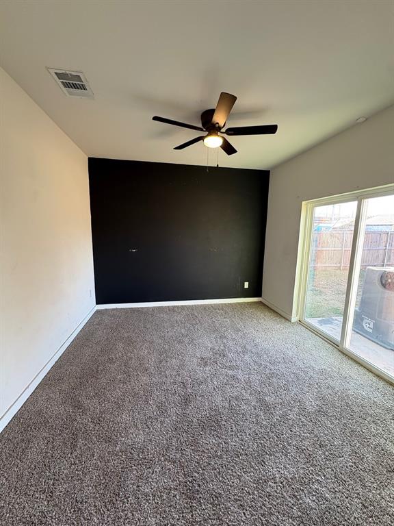 Flex room with ceiling fan and sliding doors open to patio and backyard.