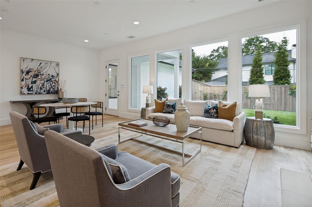 The expansive wall of windows allows abundant natural light with views of the pool sized landscaped yard with an 8' privacy fence