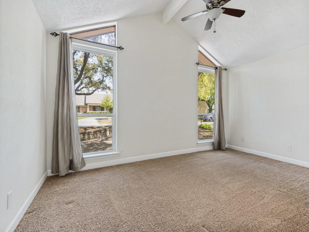 Secondary bedroom featuring a textured ceiling, light carpet, ceiling fan, and beam ceiling