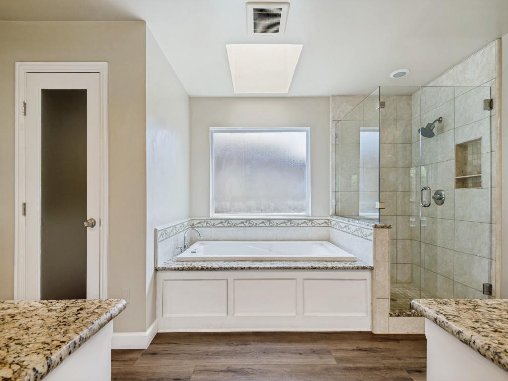 Primary Bathroom with vanity, a shower stall, a bath, and dark wood-type flooring