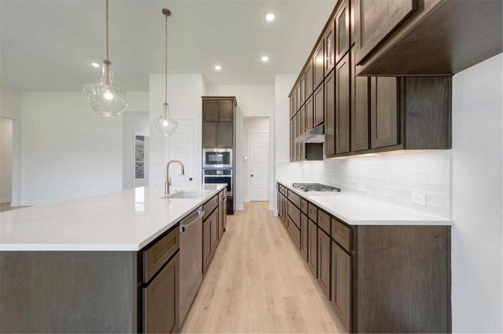 Kitchen featuring a large central island with a built-in sink and two pendant lights