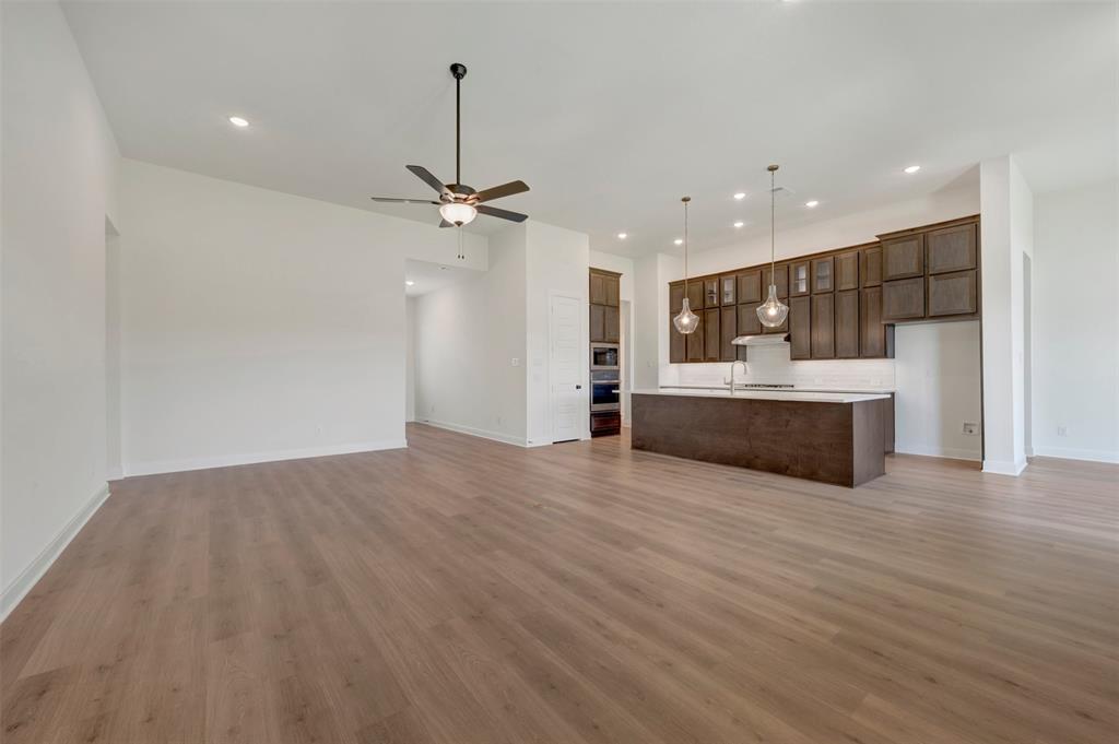 Expansive living space featuring wood-finish flooring, recessed lighting, and a ceiling fan