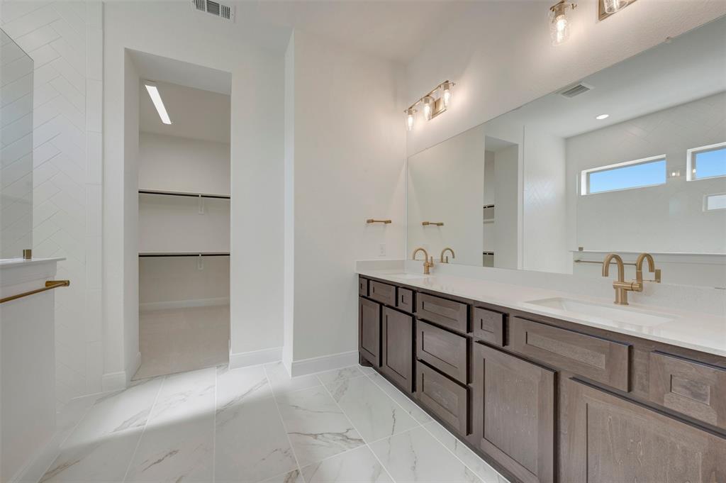Dual vanity with quartz countertops, undermount sinks, and brass-finish fixtures