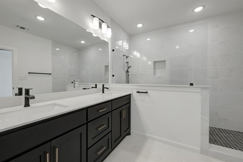Bathroom featuring a dual vanity with dark wood-finish cabinetry and light-toned countertops