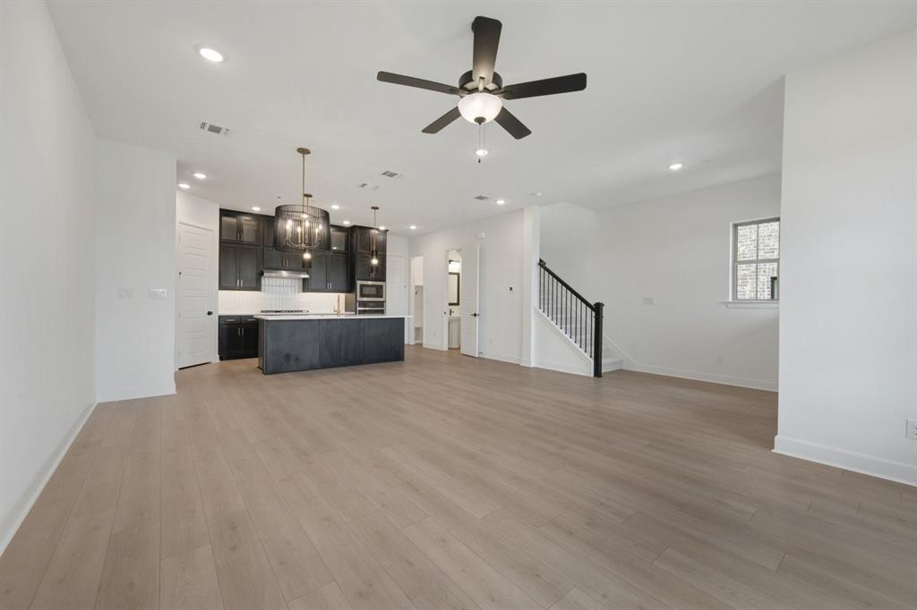 Open-concept living space featuring wood-finish flooring, recessed lighting, and a modern ceiling fan