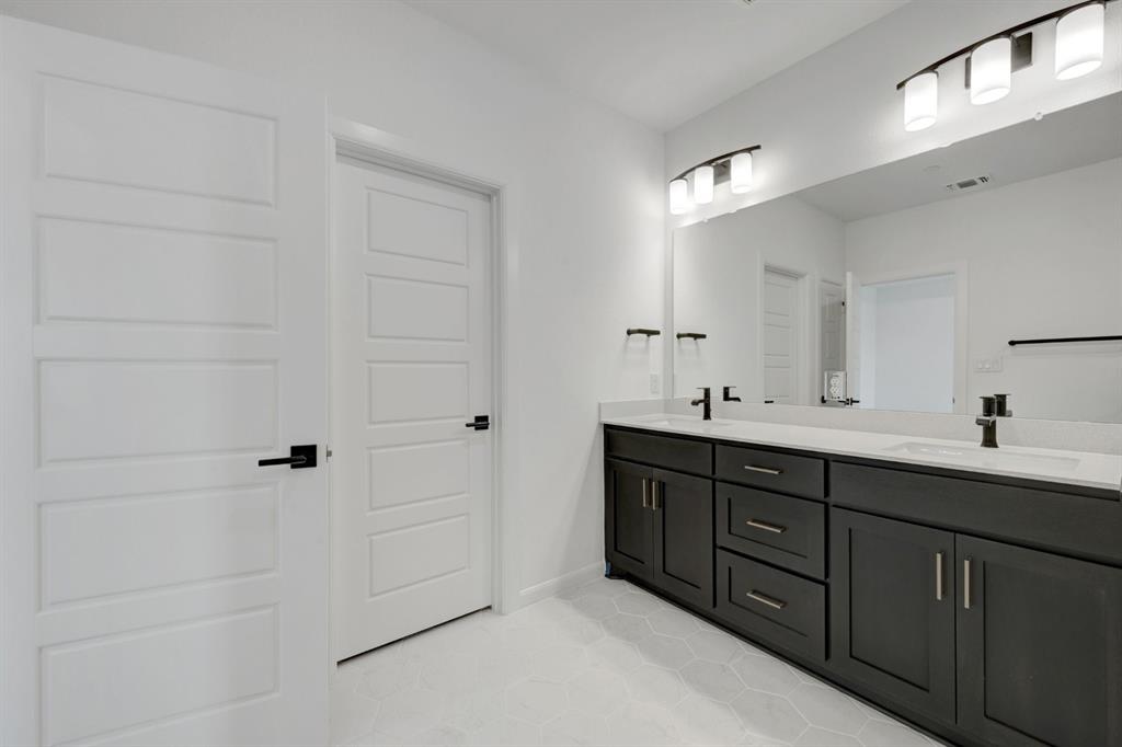 Dual vanity with dark wood cabinetry, white countertops, and matte black fixtures