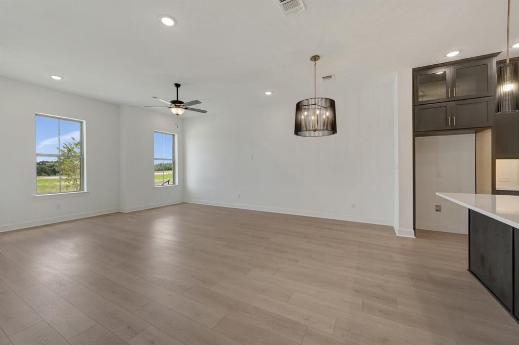 Open concept living area featuring light wood-finish flooring, recessed lighting, and a ceiling fan