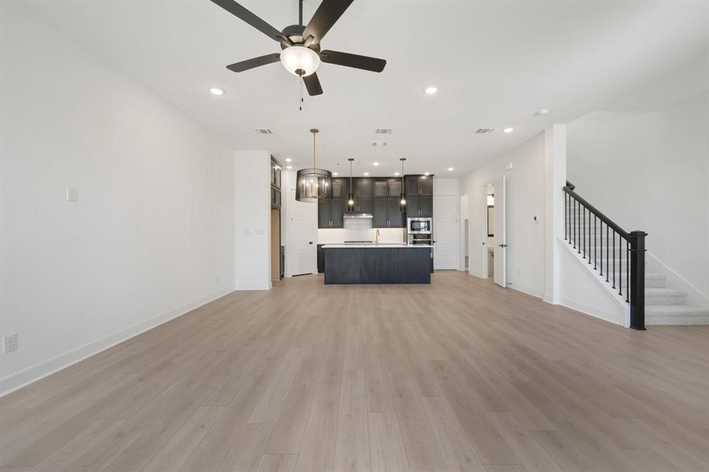 Open-concept living space featuring wood-finish flooring, recessed lighting, and a contemporary ceiling fan