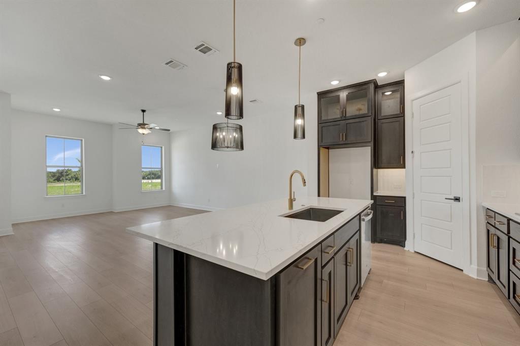 Open-concept kitchen and living area featuring light wood-finish flooring