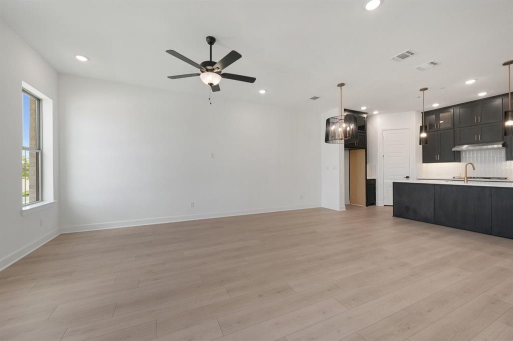 Expansive room featuring light wood-finish flooring and recessed lighting