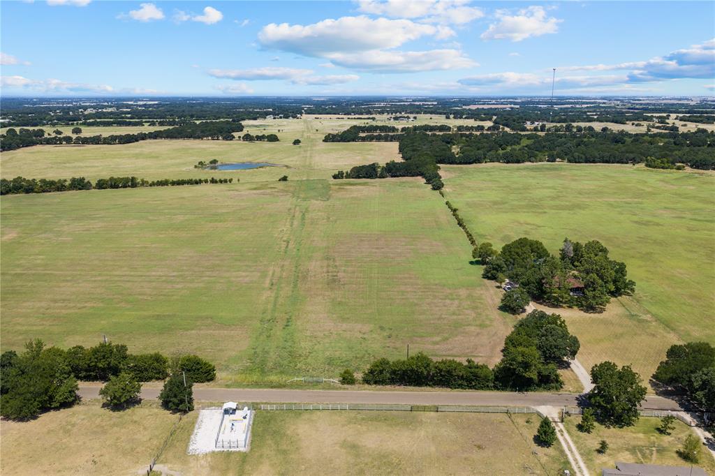 Expansive acreage featuring a private pond, mature tree lines, and a dedicated access road