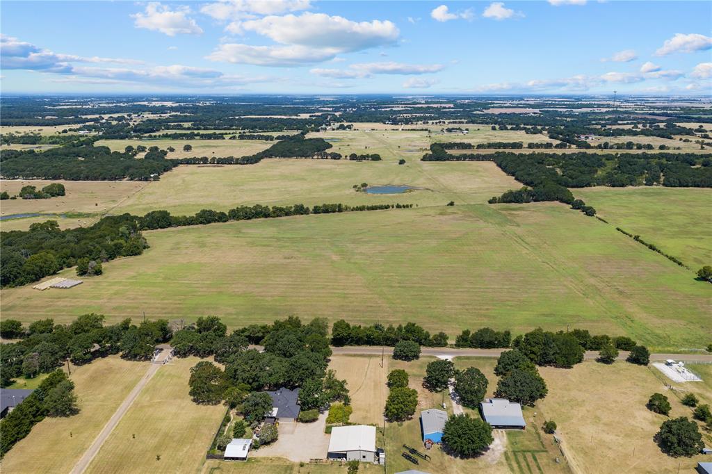 Expansive rural landscape featuring a mix of open fields and mature tree lines