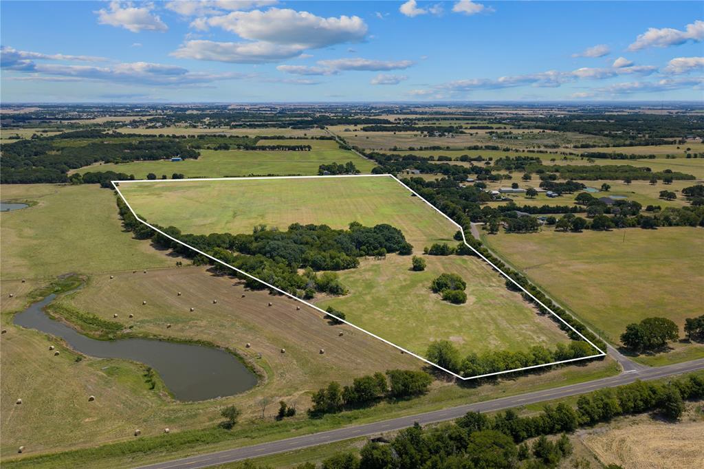Expansive parcel featuring open fields, wooded areas, and a visible pond Expansive parcel featuring open fields, wooded areas, and a visible pond