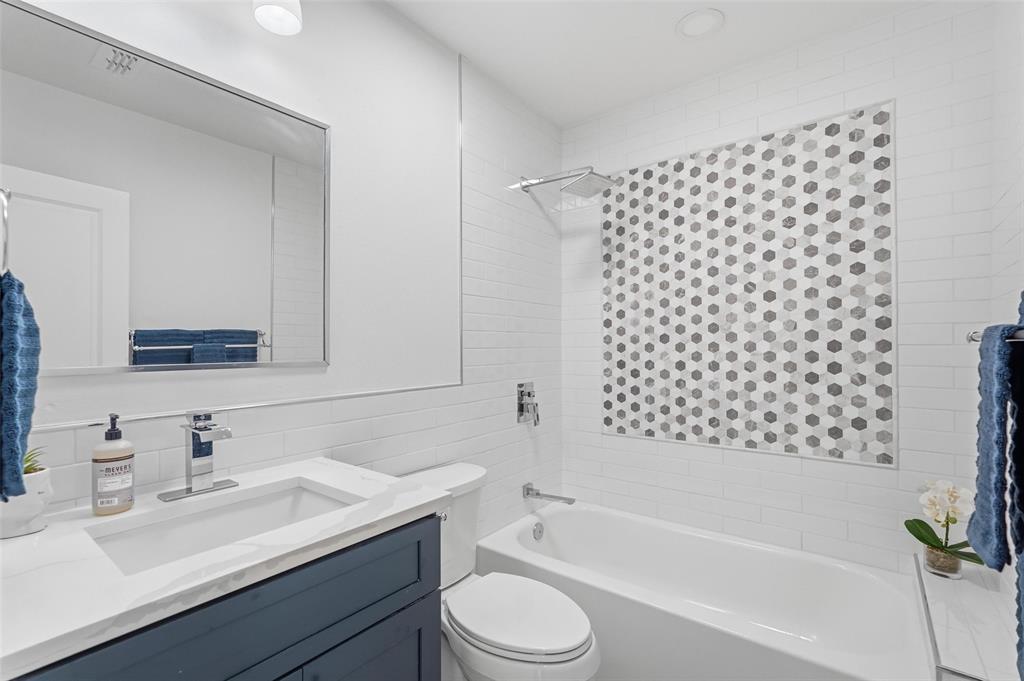 Upgraded bathroom featuring brand new tile and custom cabinetry for a fresh, modern feel.