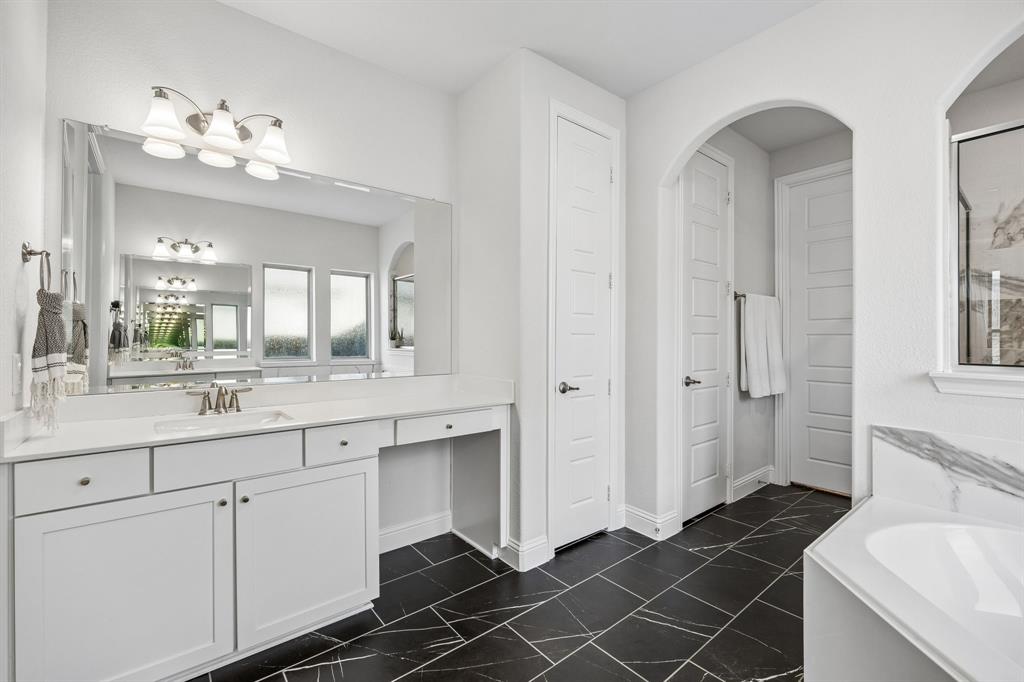 Bathroom with vanity and a bath