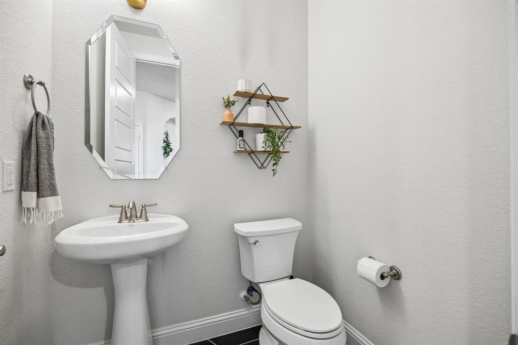Bathroom featuring toilet and a textured wall