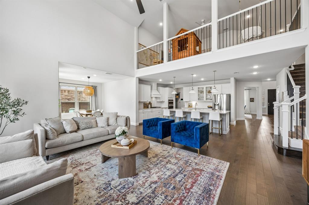 Living area featuring recessed lighting, dark wood-style flooring, a ceiling fan, and a high ceiling